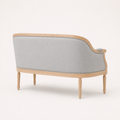Rear profile | Right-rear studio view of the loveseat's continuous black upholstered back, birch rails, and four legs