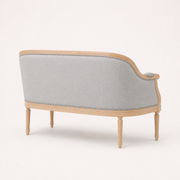 Rear profile | Right-rear studio view of the loveseat's continuous black upholstered back, birch rails, and four legs