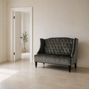 Scale | charcoal gray velvet diamond-tufted wingback loveseat beside a full-height interior doorway for scale