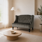 Angle | front-right view of the charcoal gray velvet diamond-tufted wingback loveseat in the warm-white living room