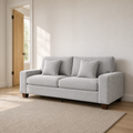 Scale | Light gray chenille sofa beside a full-height interior doorway in a warm neutral entry
