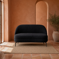 Terracotta room | Black boucle armless loveseat in an arched terracotta sitting room