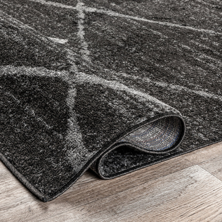 Folded corner | one corner turned back on a wood floor to show the backing