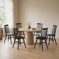 In a room | all six matching black Windsor dining chairs pulled up to a round table in a warm flax dining room, bright soft midday light
