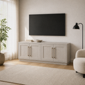 In a warm white living room | Alder White four-door TV stand beneath a wall-mounted TV with a pale oak floor and plain rug