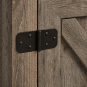 Hinge close-up | Dark metal barn-door hinge, screws and gray-washed X-brace wood