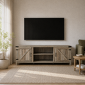 Living room | Gray-washed barn-door TV stand beneath a wall-mounted television in a light living room