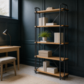 Blue-green library | ladder bookcase styled with art books and archival boxes under cool side-window light