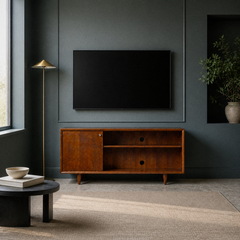 In a room | mahogany cherry TV stand against a deep blue-green paneled wall beneath a blank screen, with a brass lamp and plain rug