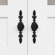 Hardware | close-up of the black cast fleur-de-lis door pulls at a center seam