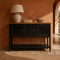 In a room | black console with a natural brown wood top in a terracotta dining room with an arched doorway
