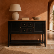 In a room | black console with a natural brown wood top in a terracotta dining room with an arched doorway