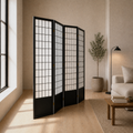 Warm loft angle | black four-panel divider from a strong side angle beside a tall window and cream seating