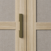 Pull close-up | dark antique-brass rectangular bar pull between pale oak door frames and woven linen panels