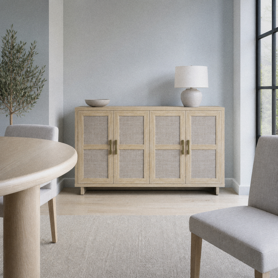 Cool blue dining room | pale natural oak sideboard between a round table and a right-side black-framed window
