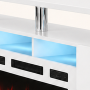 Hardware | close hardware detail of a chrome post, white upper shelf, blue-lit media bay and black grille on the fireplace TV stand