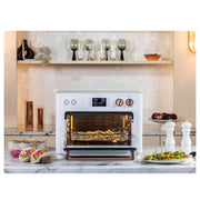 Kitchen | Air fry toaster oven on a kitchen countertop with a white backsplash and matte black kettle beside it