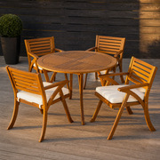 On the deck | round acacia table and four chairs on a redwood deck at golden hour