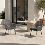 Scale | two gray open-back wicker dining armchairs beside a full-height doorway on a terrace
