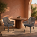 Room | two gray open-back wicker dining armchairs with gray seat cushions in a warm terracotta courtyard