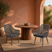 Room | two gray open-back wicker dining armchairs with gray seat cushions in a warm terracotta courtyard