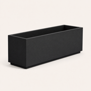 Studio angle | empty matte charcoal-black composite trough planter showing its long face, short end, and open cavity
