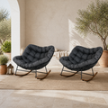 In a room | mediterranean courtyard with two dark gray cushioned rocking chairs, black steel frames and warm wood-grain runners