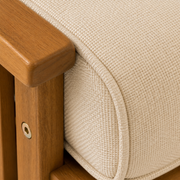 Texture | close view of the cream cushion weave, self piping, and warm brown acacia arm rail