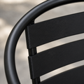 Texture | macro view of the black tubular arm and ribbed metal back slats