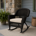 Blue-gray porch | espresso resin-wicker rocking chair with pale tan seat cushion beside a stone chimney