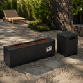 Garden terrace | Fire table and separate tank cover on gravel and stone pavers beside a dark brick wall