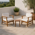 Room | Two warm-brown acacia club chairs with cream cushions and one slatted side table on a limestone terrace