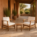Room | Two warm-brown acacia club chairs with cream cushions and one slatted side table beneath a cedar pergola