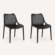 Studio three-quarter | Two Black molded-plastic stacking chairs showing the diamond lattice and seat depth