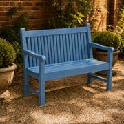 In a room | blue slatted poly lumber garden bench in a brick garden courtyard