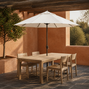 Terracotta courtyard | one off-white octagonal umbrella over a wood dining table with dark bronze pole and four chairs