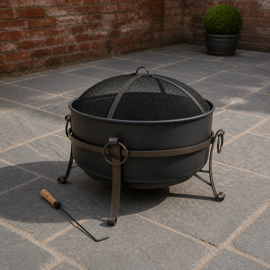 Red brick courtyard | Dark steel cauldron fire pit with mesh spark screen and wood-handled poker