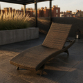 In a room | dark wicker chaise lounge on a charcoal rooftop terrace at evening