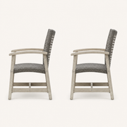 Studio side | Side profiles of two light gray-washed acacia club chairs with dark wicker seats