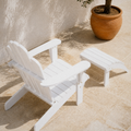 Complete set | White painted Adirondack chair and matching ottoman viewed from above on a pale stone terrace