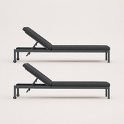 Studio side | Side profile of two dark gray reclining chaise lounges with raised back supports and wheels