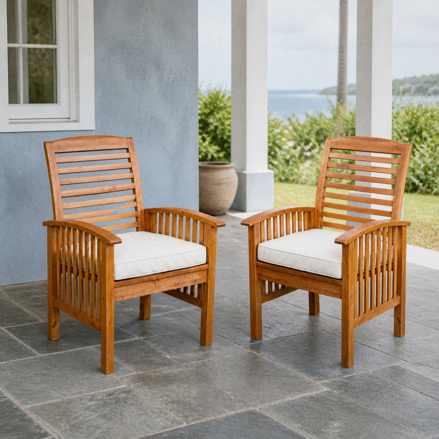 In a room | two warm-brown acacia dining armchairs with ivory seat cushions on a cool blue-grey covered veranda