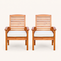 Front | pair of warm-brown acacia dining armchairs with ivory seat cushions facing forward on a clean studio backdrop