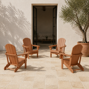 Scale | four warm teak-tone folding Adirondack chairs on a limestone courtyard in front of a full-height open doorway