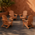 In a room | four warm teak-tone folding Adirondack chairs on dark basalt pavers against terracotta plaster, citrus tree at left