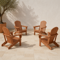Set of four | four warm teak-tone folding Adirondack chairs arranged on pale limestone pavers beside a terracotta planter