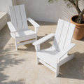 Elevated three-quarter view of two white HDPE Adirondack chairs on a limestone terrace