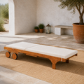 Sunlit courtyard, laid flat | eucalyptus chaise as a level cream-cushioned sunbed with disc wheels