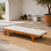 Sunlit courtyard, laid flat | eucalyptus chaise as a level cream-cushioned sunbed with disc wheels