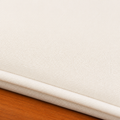 Cushion texture | close view of the plain cream woven cover, self-piping, and eucalyptus rail